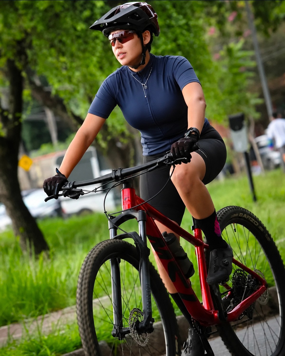 Marina Amancio pedalando em uma ciclovia arborizada